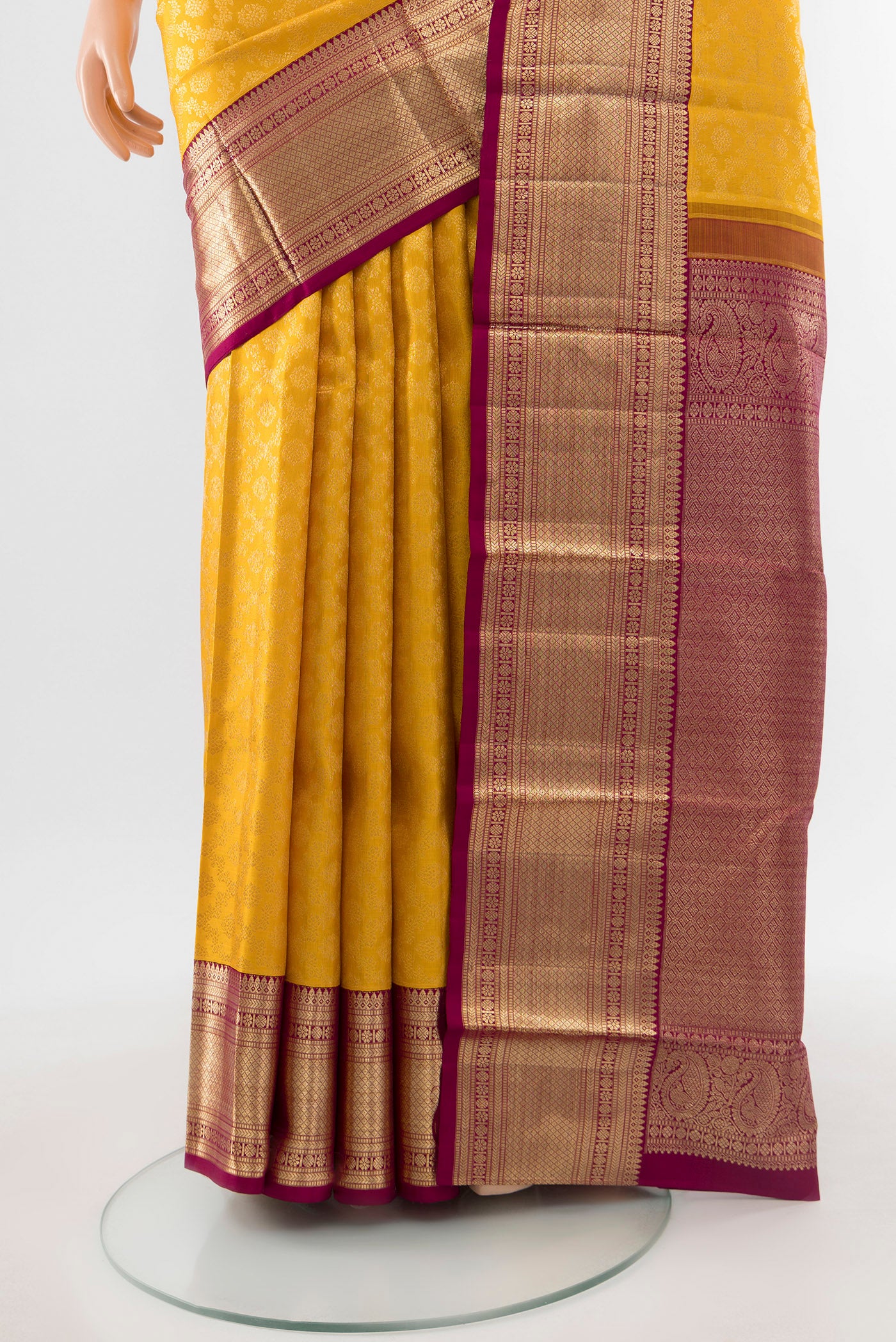 Pleats and pallu of Pure Silk Pure Zari Mustard Kanchipuram Saree with Zari Butta on the body and Silk Border. 