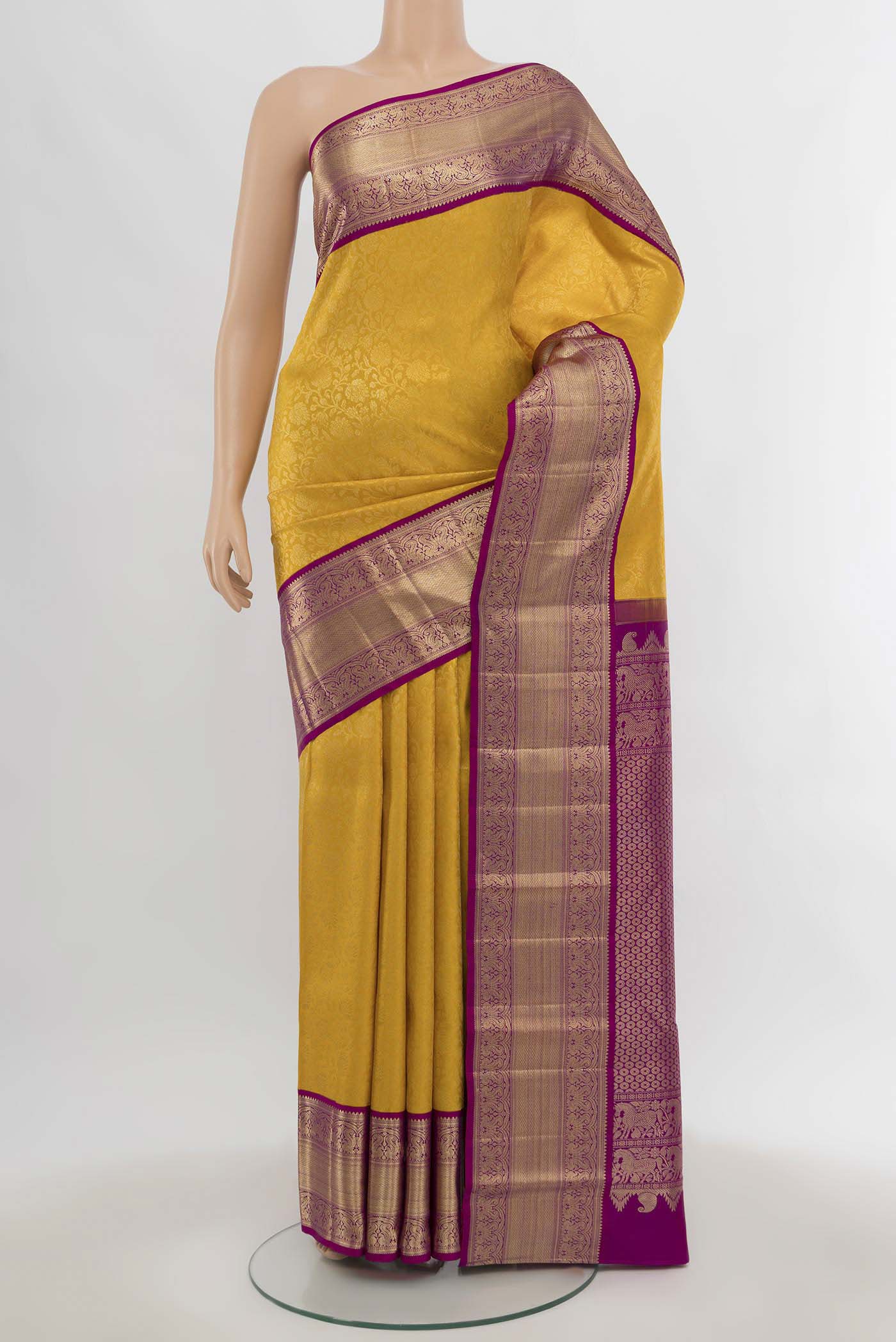 Yellow Kanchipuram Silk Saree with Zari Butta on the body and Silk Border.  displayed on a mannequin