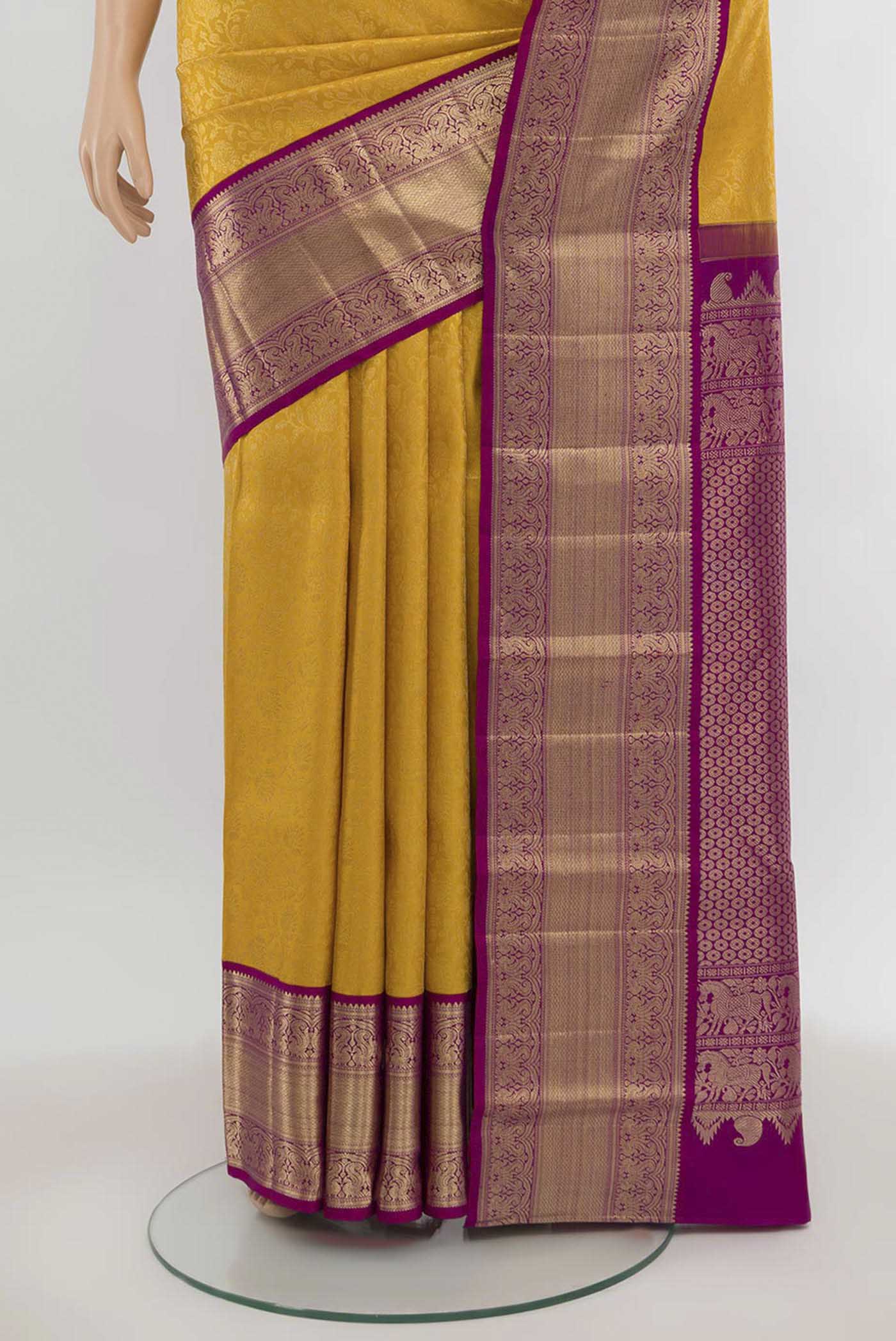 Pleats and pallu of Yellow Kanchipuram Silk Saree with Zari Butta on the body and Silk Border. 
