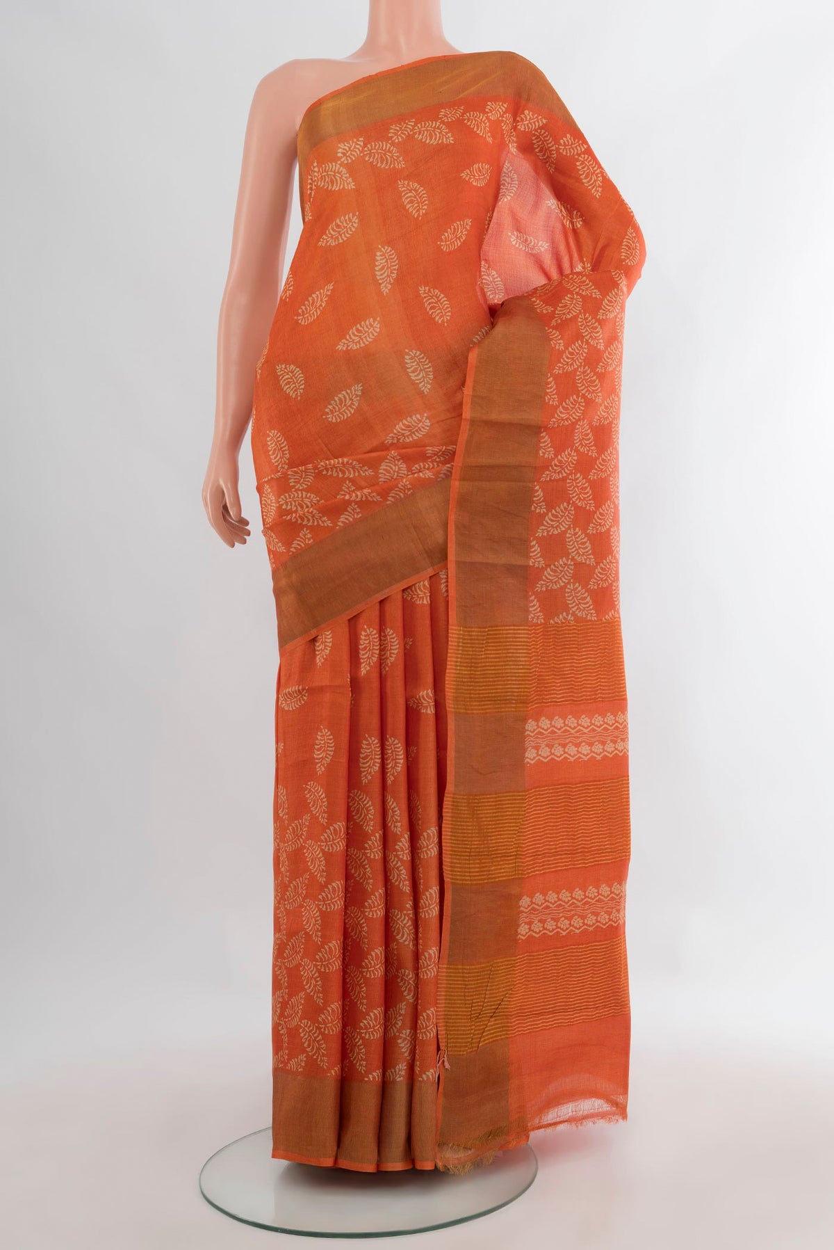 Orange Tussar Saree with Floral Print on the body and Zari Border.  displayed on a mannequin