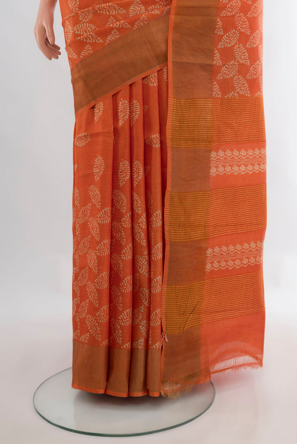 Pleats and pallu of Orange Tussar Saree with Floral Print on the body and Zari Border. 