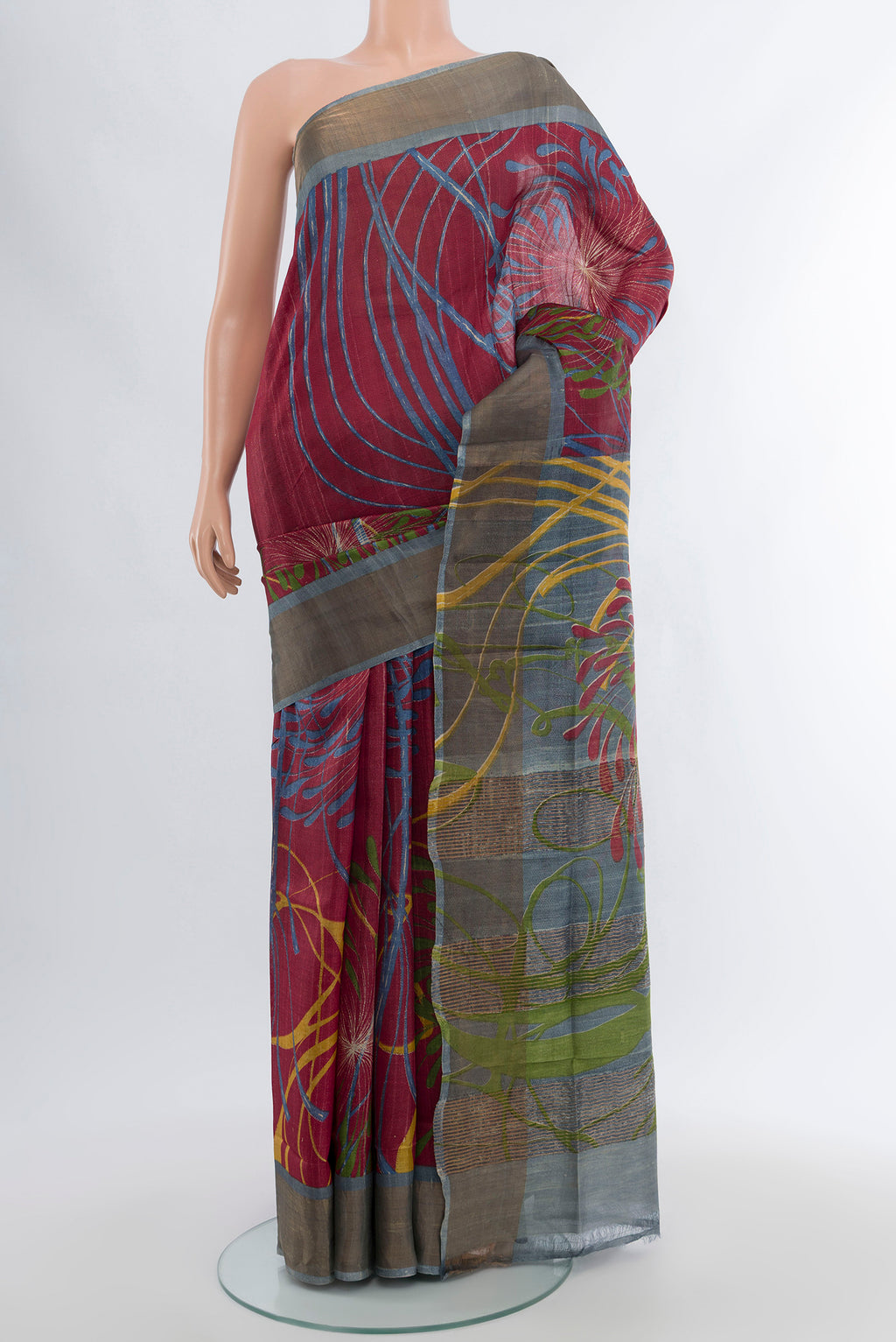 Maroon Tussar Silk Saree with Floral Print on the body and Zari Border.  displayed on a mannequin