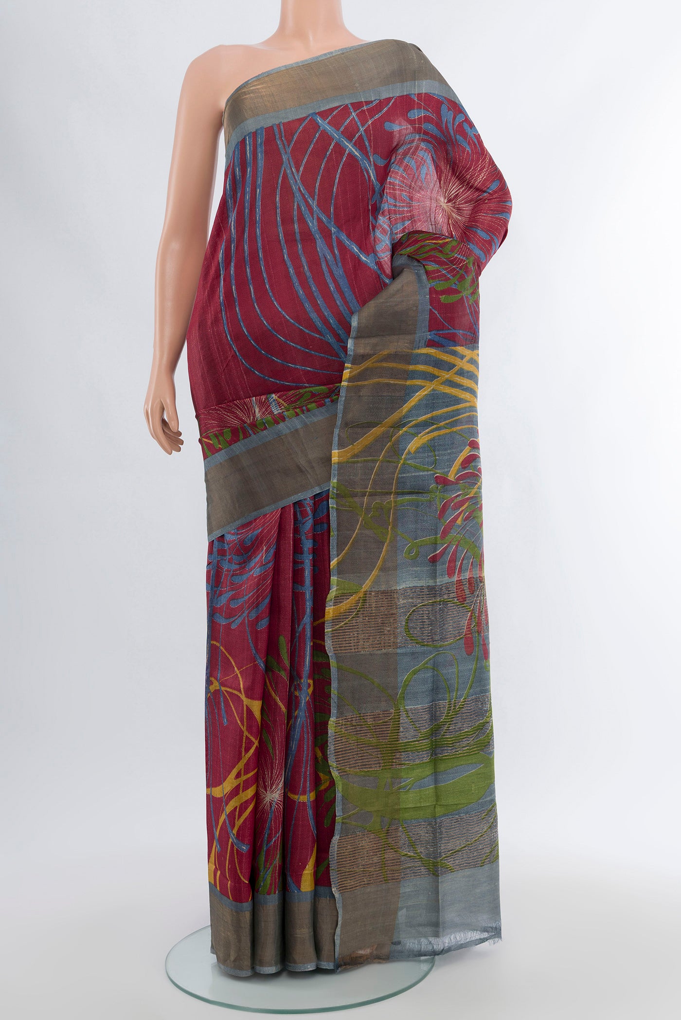 Maroon Tussar Silk Saree with Floral Print on the body and Zari Border.  displayed on a mannequin