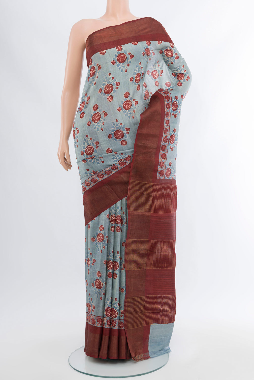 Grey Tussar Silk Saree with Floral Print on the body and Zari Border.  displayed on a mannequin