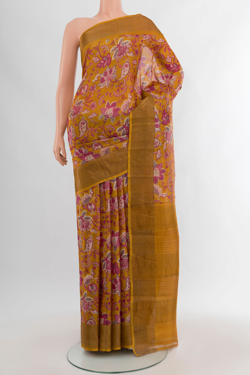 Mustard Tussar Silk Saree with Floral Print on the body and Zari Border.  displayed on a mannequin