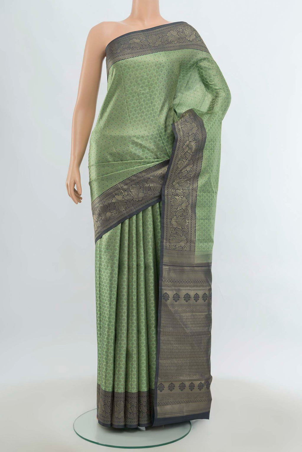 Light Green Kanchipuram Silk Saree with Zari Butta on the body and Silk Border.  displayed on a mannequin