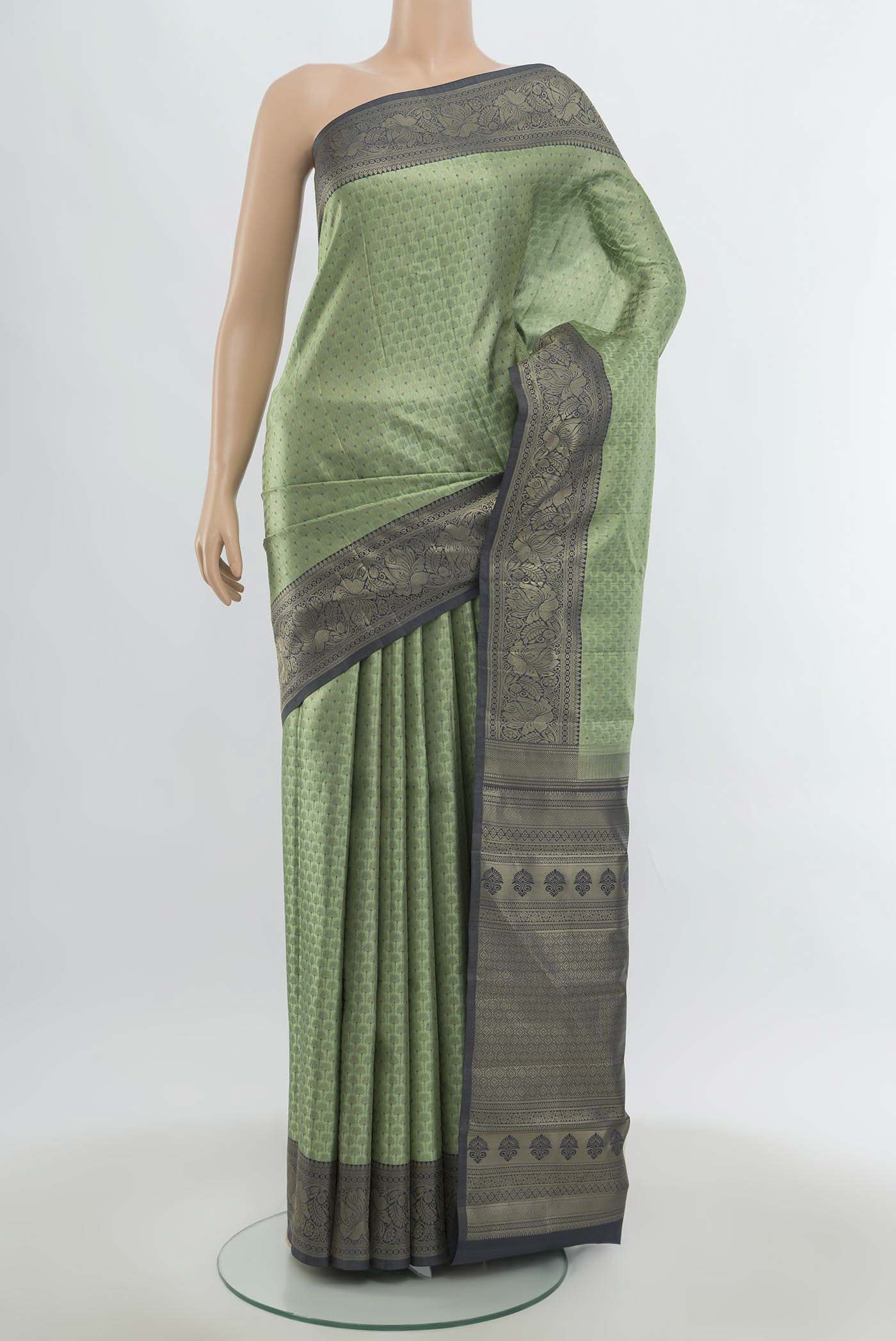 Light Green Kanchipuram Silk Saree with Zari Butta on the body and Silk Border.  displayed on a mannequin