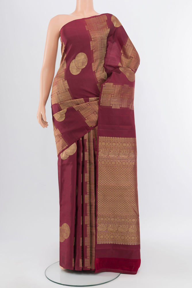 Pure Silk Pure Zari Maroon Kanchipuram Saree with Zari Butta on the body and Silk Border.  displayed on a mannequin
