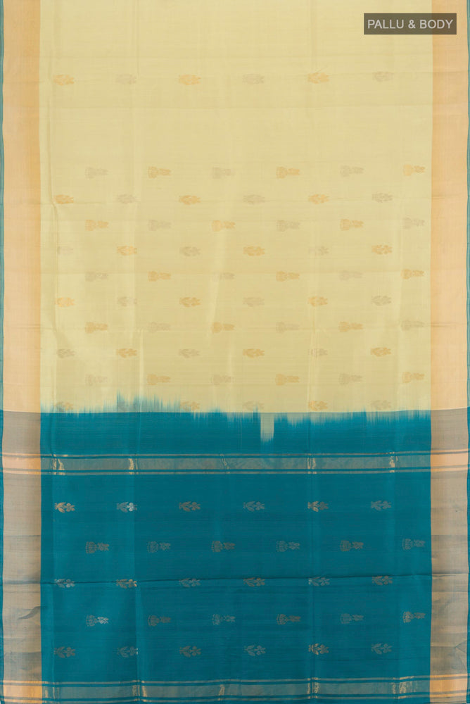Flat view of Cream Uppada Silk Saree with Zari Butta on the body and Silk Border. 