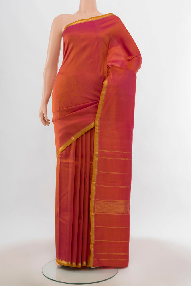 Peach Kanjivaram Silk Saree with Zari Butta on the body and Silk Border.  displayed on a mannequin