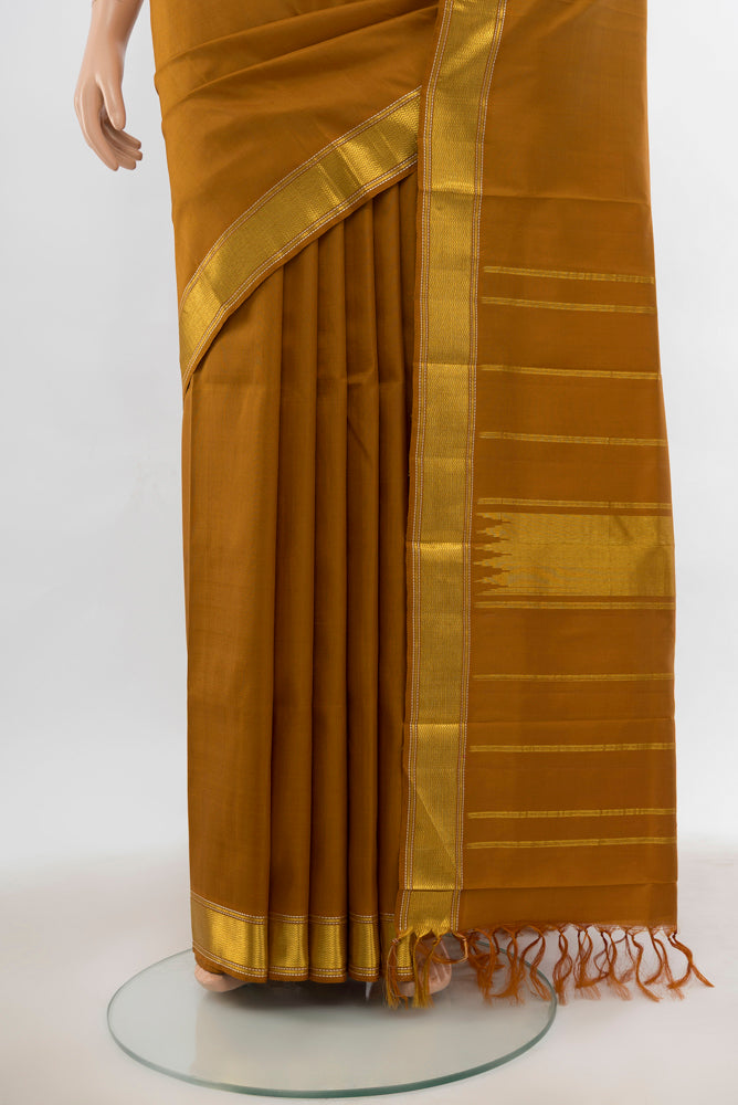 Pleats and pallu of Brown Kanjivaram Silk Saree with Plain Body and Silk Border. 