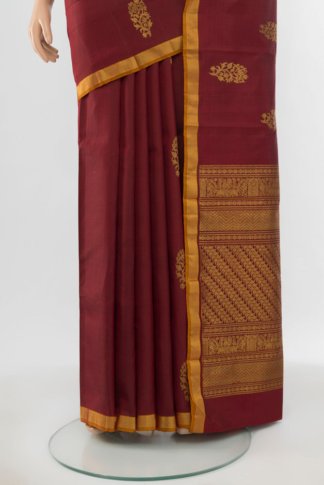 Pleats and pallu of Pure Silk Pure Zari Maroon Kanchipuram Saree with Zari Butta on the body and Silk Border. 