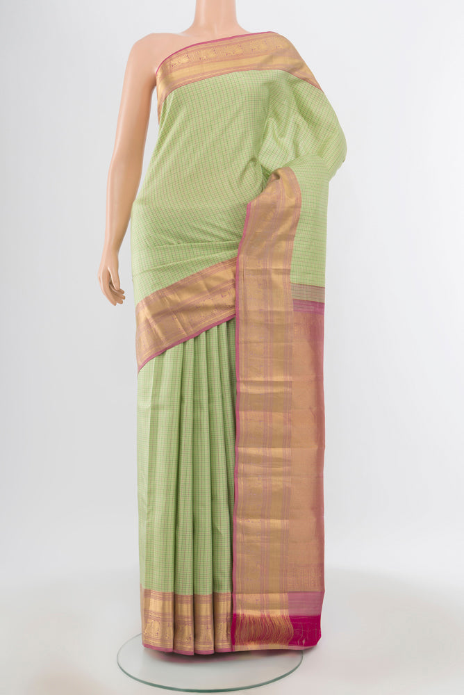 Pista Green Kanchipuram Silk Saree with Zari Butta on the body and Silk Border.  displayed on a mannequin