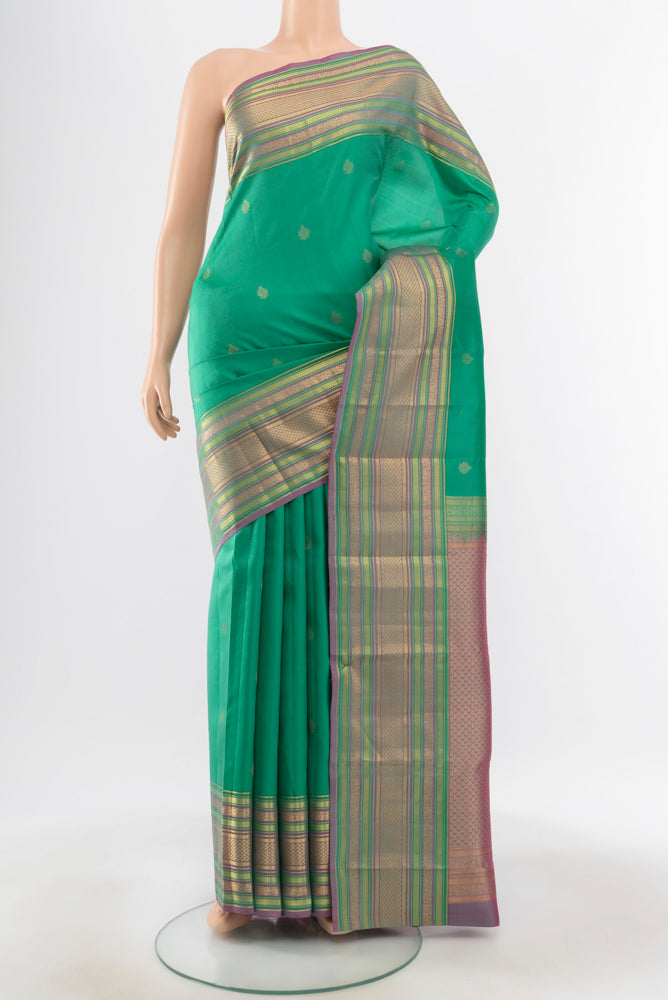 Pure Silk Pure Zari Light Blue Kanchipuram Saree with Zari Butta on the body and Silk Border.  displayed on a mannequin
