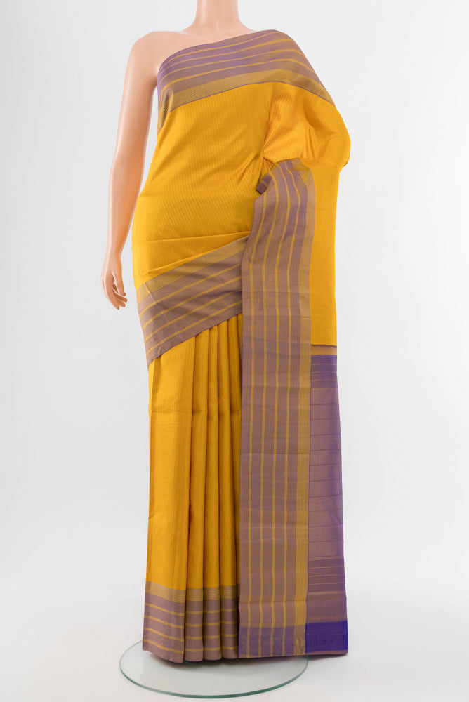 Mustard Kanchipuram Silk Saree with Zari Butta on the body and Silk Border.  displayed on a mannequin