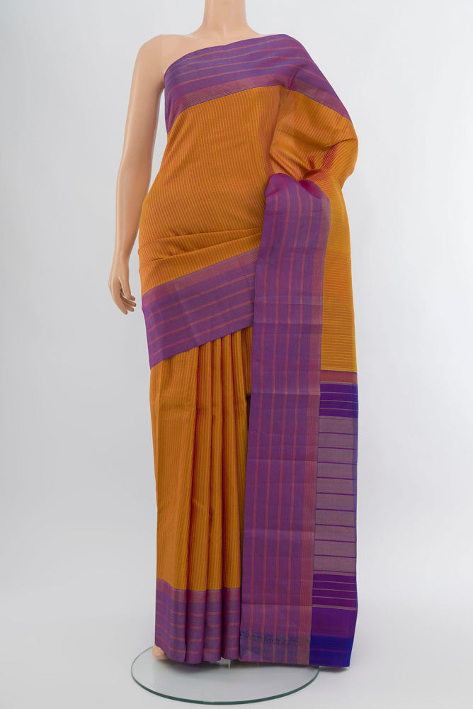Rust Kanchipuram Silk Saree with Zari Butta on the body and Silk Border.  displayed on a mannequin