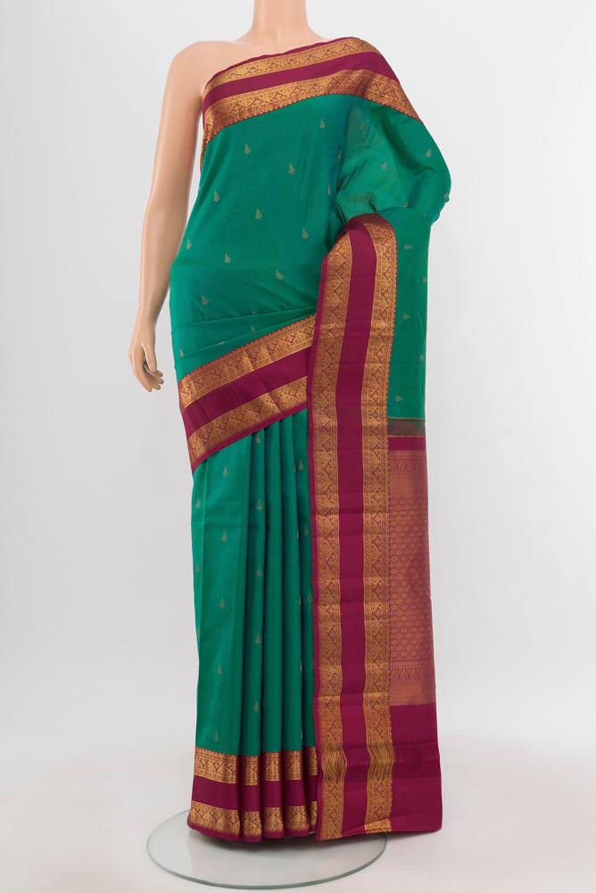 Peacock Blue Kanchipuram Silk Saree with Zari Butta on the body and Silk Border.  displayed on a mannequin