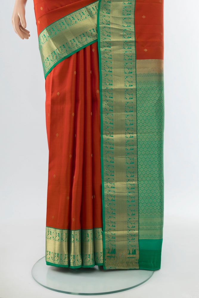 Pleats and pallu of Rust Kanchipuram Silk Saree with Zari Butta on the body and Silk Border. 