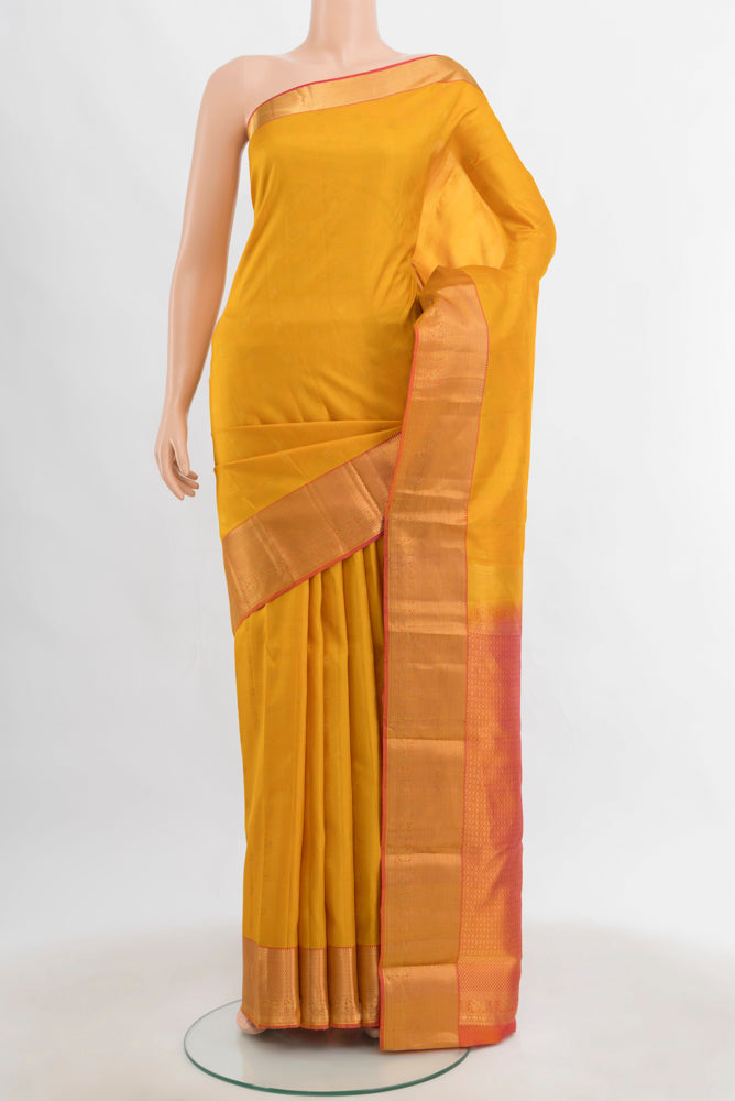 Mustard Kanchipuram Silk Saree with Zari Butta on the body and Silk Border.  displayed on a mannequin