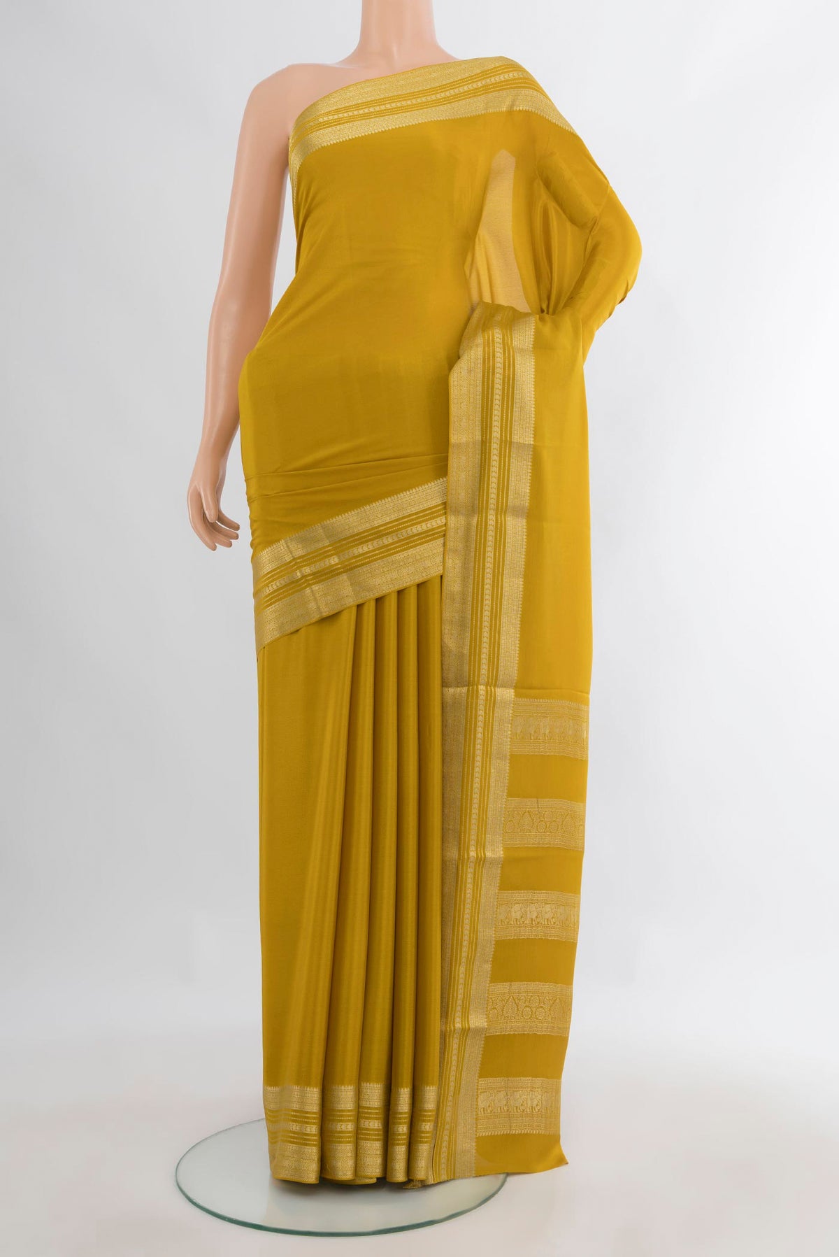 Mustard Mysore Crepe Saree with Plain Body and Zari Border.  displayed on a mannequin