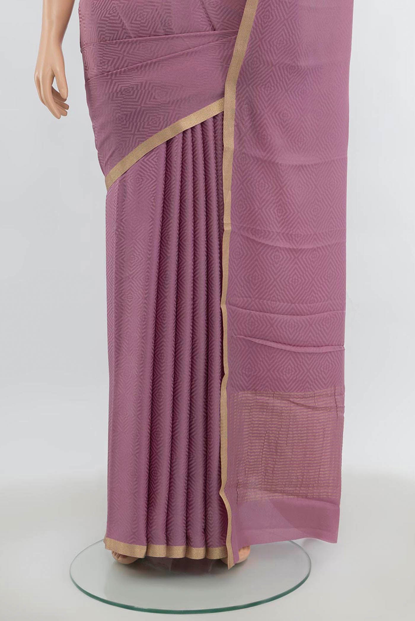 Pleats and pallu of Bronze Mysore Crepe Saree with Zari Butta on the body and Silk Border. 