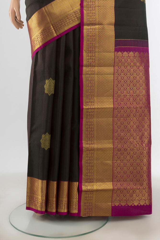 Pleats and pallu of Black Kanchipuram Silk Saree with Zari Butta on the body and Silk Border. 