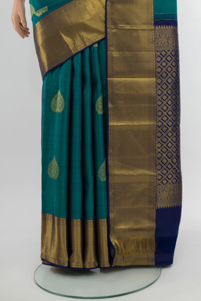 Pleats and pallu of Peacock Blue Kanchipuram Silk Saree with Zari Butta on the body and Silk Border. 