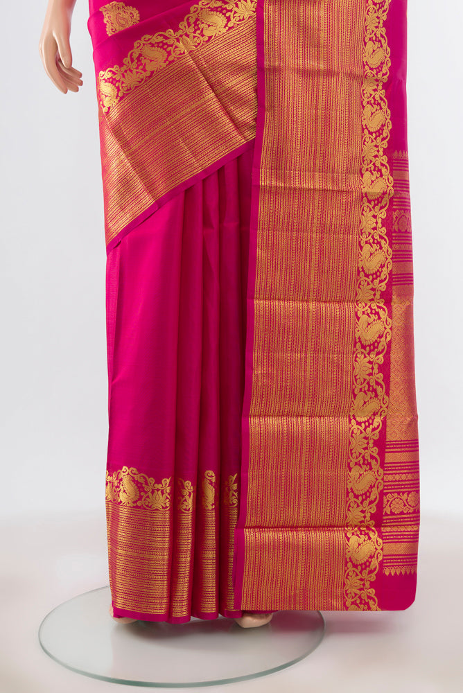 Pleats and pallu of Pure Silk Pure Zari Magenta Kanchipuram Saree with Zari Butta on the body and Silk Border. 