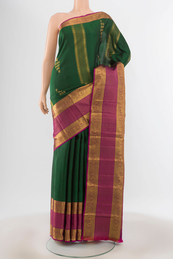 Pure Silk Pure Zari Bottle Green Kanchipuram Saree with Zari Butta on the body and Silk Border.  displayed on a mannequin