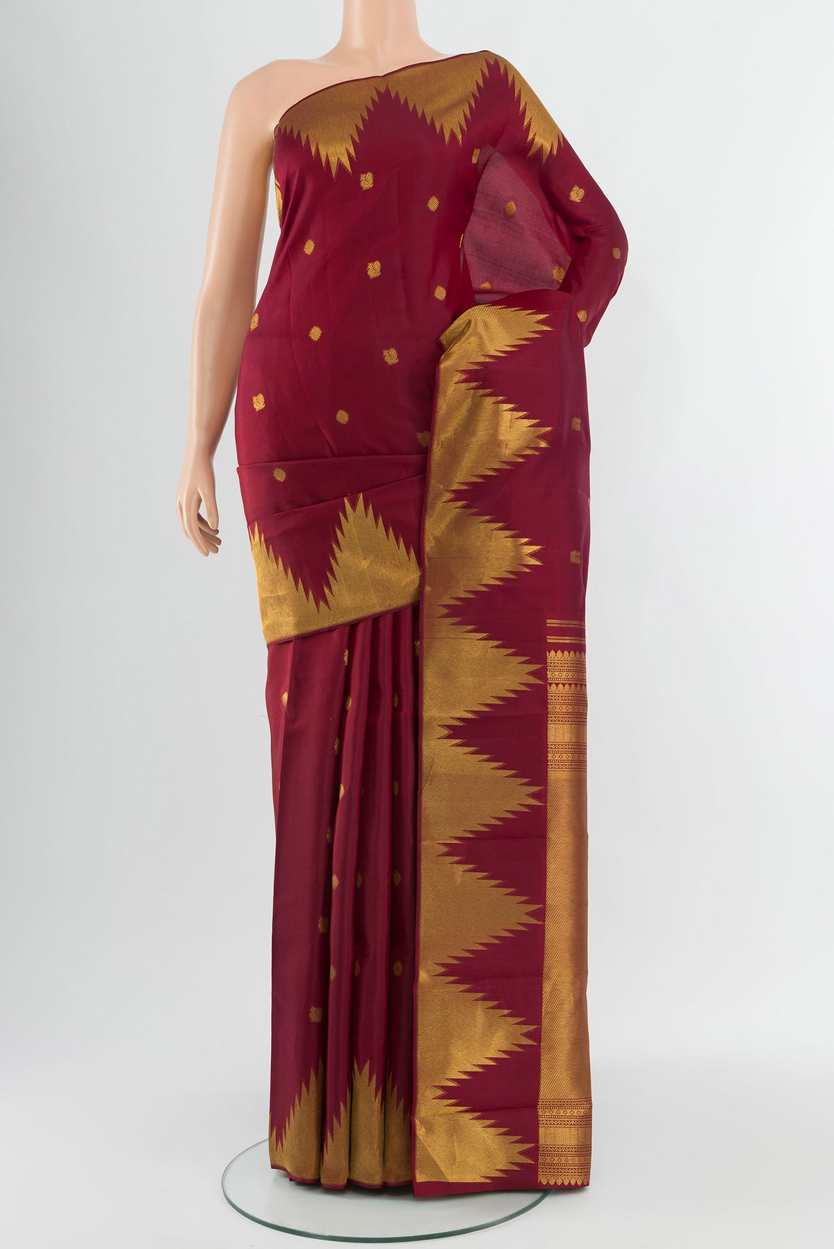 Maroon Kanchipuram Silk Saree with Zari Butta on the body and Temple Border.  displayed on a mannequin