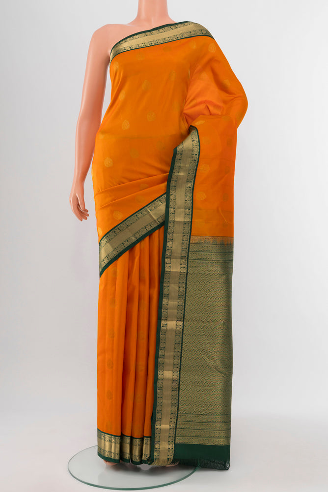 Yellow Kanchipuram Silk Saree with Zari Butta on the body and Silk Border.  displayed on a mannequin