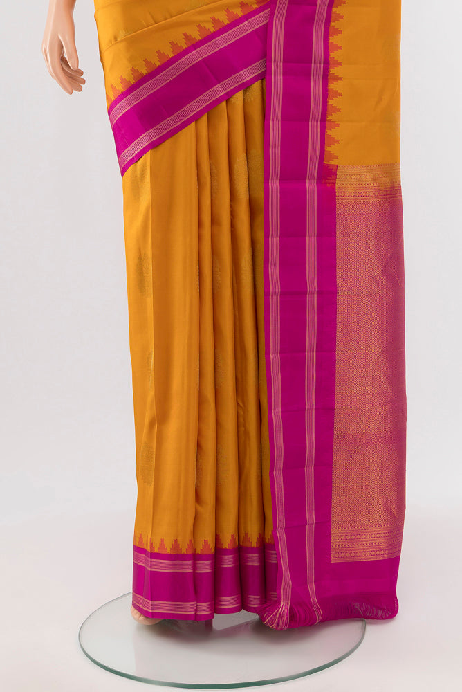 Pleats and pallu of Mustard Kanchipuram Silk Saree with Zari Butta on the body and Silk Border. 