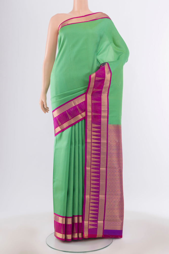 Light Green Kanjivaram Silk Saree with Zari Butta on the body and Silk Border.  displayed on a mannequin