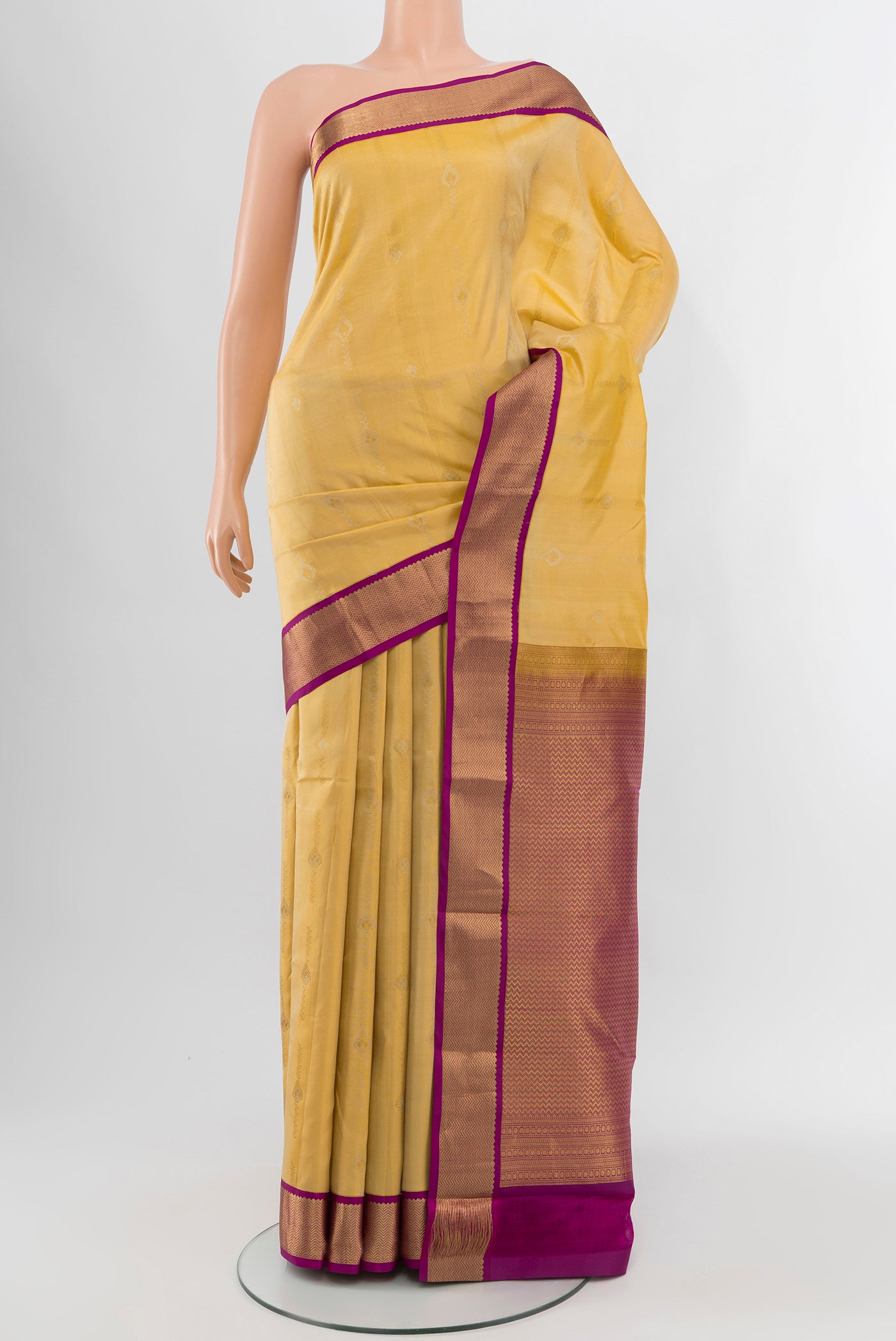 Yellow Kanchipuram Silk Saree with Zari Butta on the body and Zari Border.  displayed on a mannequin