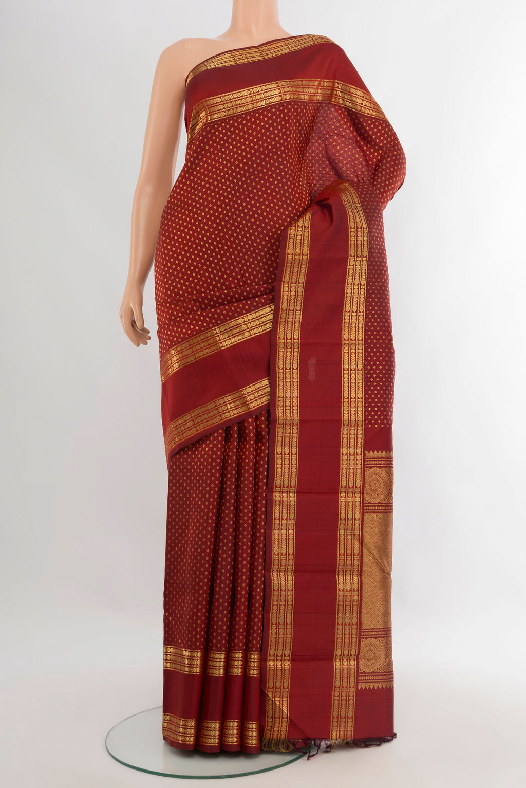 Maroon Kanjivaram Silk Saree with Zari Butta on the body and Zari Border.  displayed on a mannequin