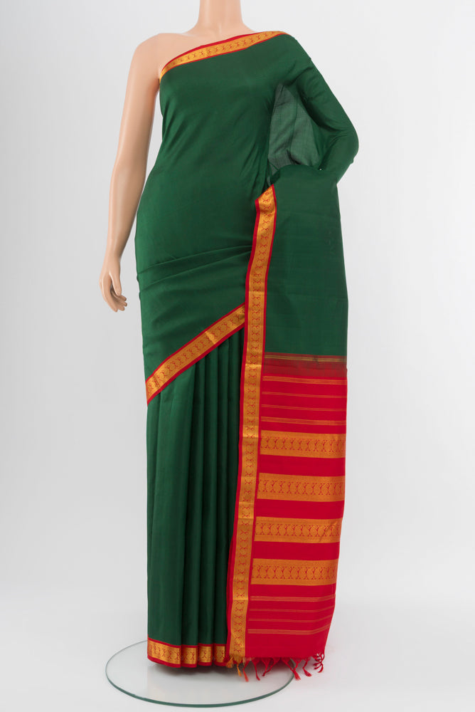 Bottle Green Kanjivaram Silk Saree with Zari Butta on the body and Silk Border.  displayed on a mannequin