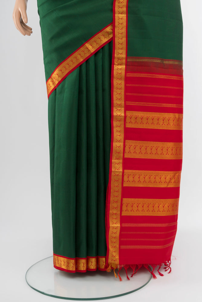 Pleats and pallu of Bottle Green Kanjivaram Silk Saree with Zari Butta on the body and Silk Border. 
