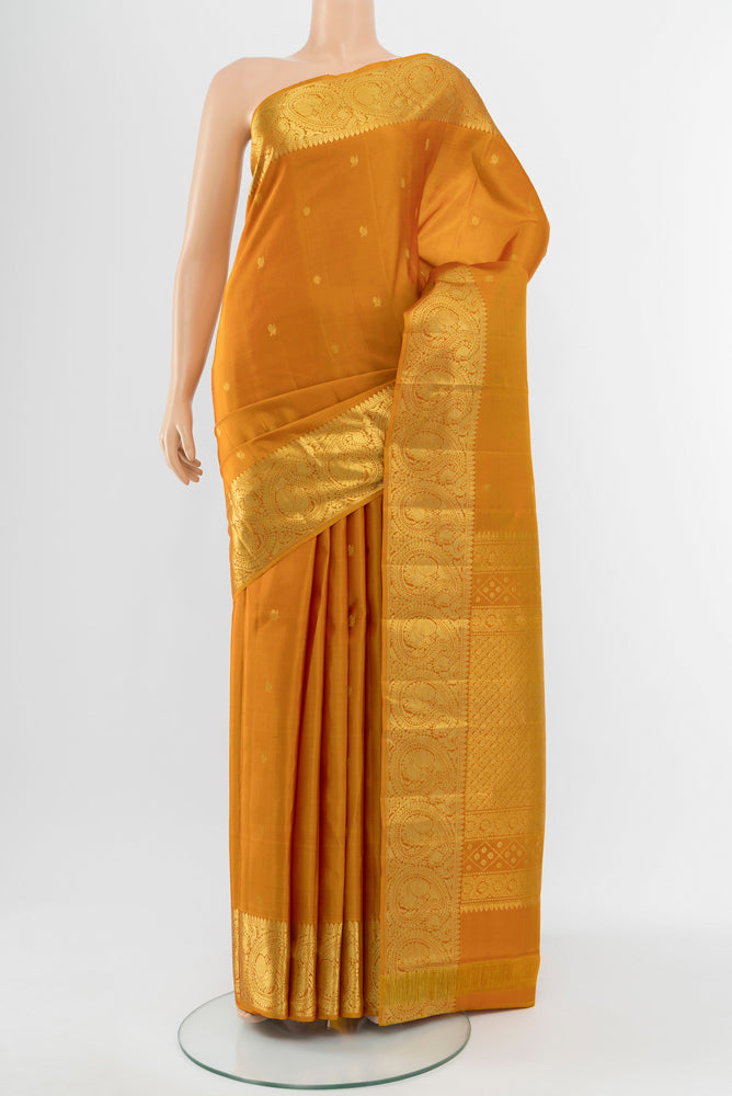 Mustard Kanchipuram Silk Saree with Zari Butta on the body and Silk Border.  displayed on a mannequin