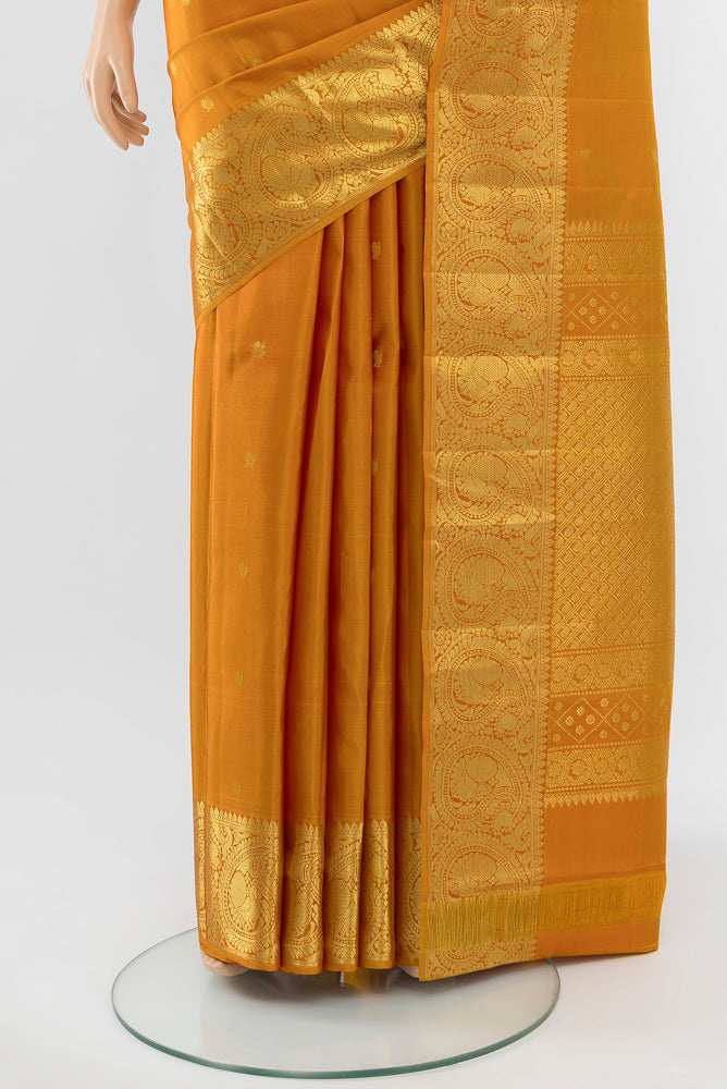 Pleats and pallu of Mustard Kanchipuram Silk Saree with Zari Butta on the body and Silk Border. 