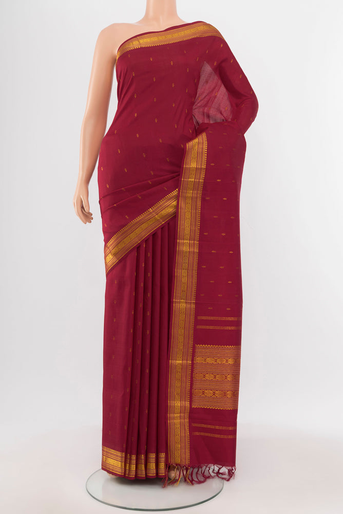Maroon Kanchipuram Silk Saree with Zari Butta on the body and Silk Border.  displayed on a mannequin