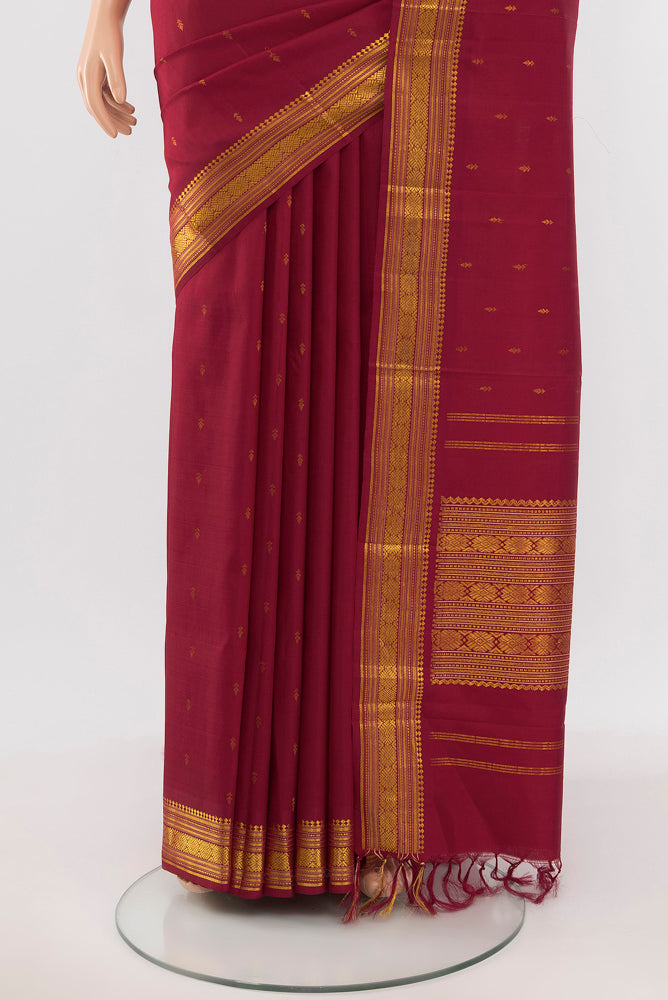 Pleats and pallu of Maroon Kanchipuram Silk Saree with Zari Butta on the body and Silk Border. 