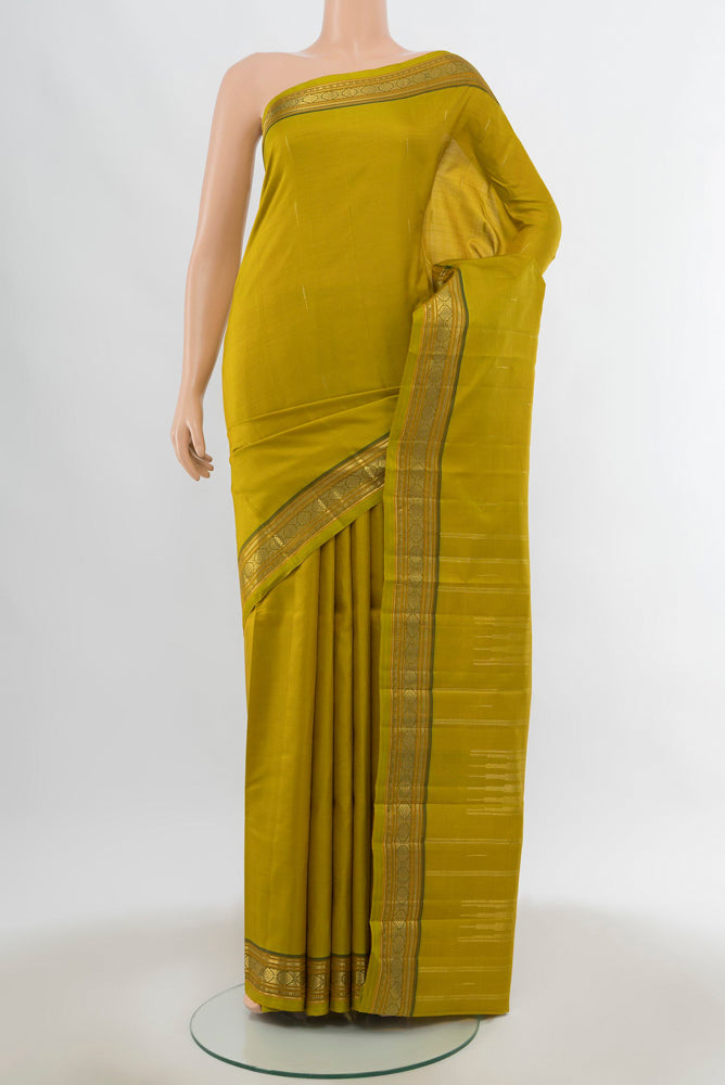 Pure Silk Pure Zari Mehandi Green Kanchipuram Saree with Zari Butta on the body and Silk Border.  displayed on a mannequin