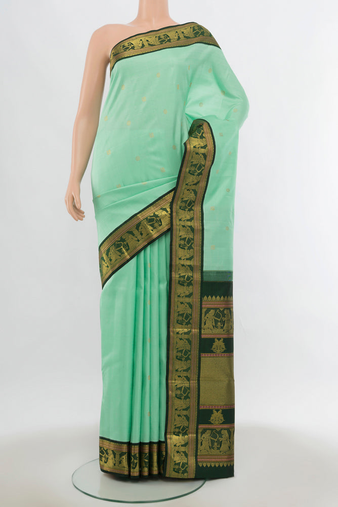 Light Green Kanjivaram Silk Saree with Zari Butta on the body and Silk Border.  displayed on a mannequin