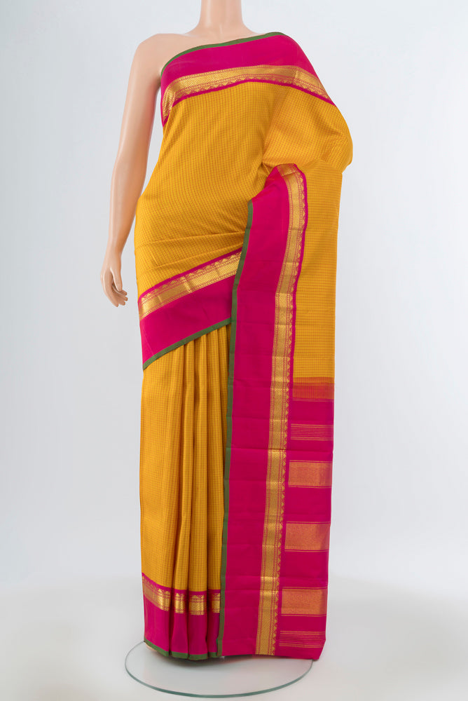 Yellow Kanjivaram Silk Saree with Zari Butta on the body and Silk Border.  displayed on a mannequin