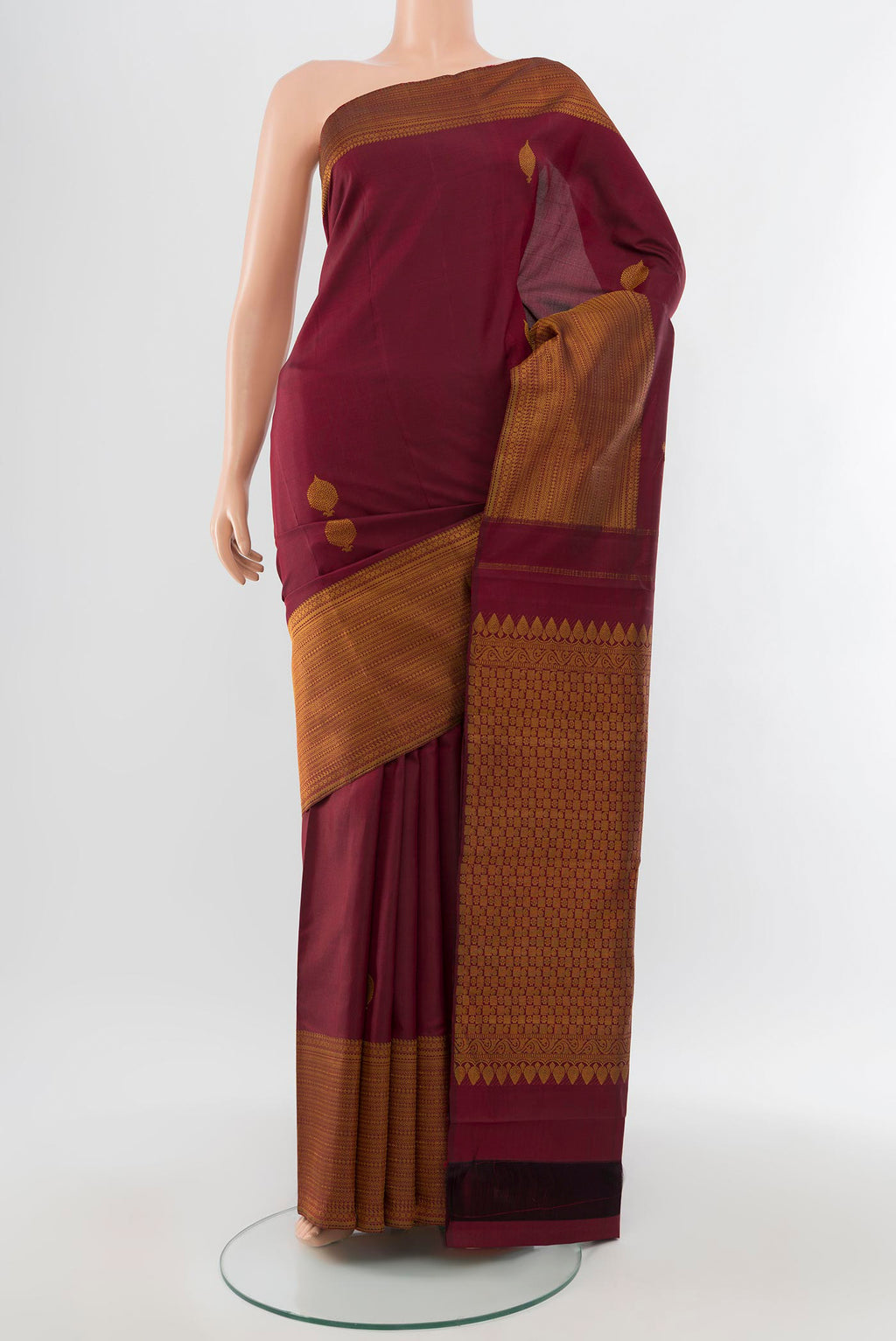 Pure Silk Pure Zari Maroon Kanjivaram Saree with Zari Butta on the body and Silk Border.  displayed on a mannequin