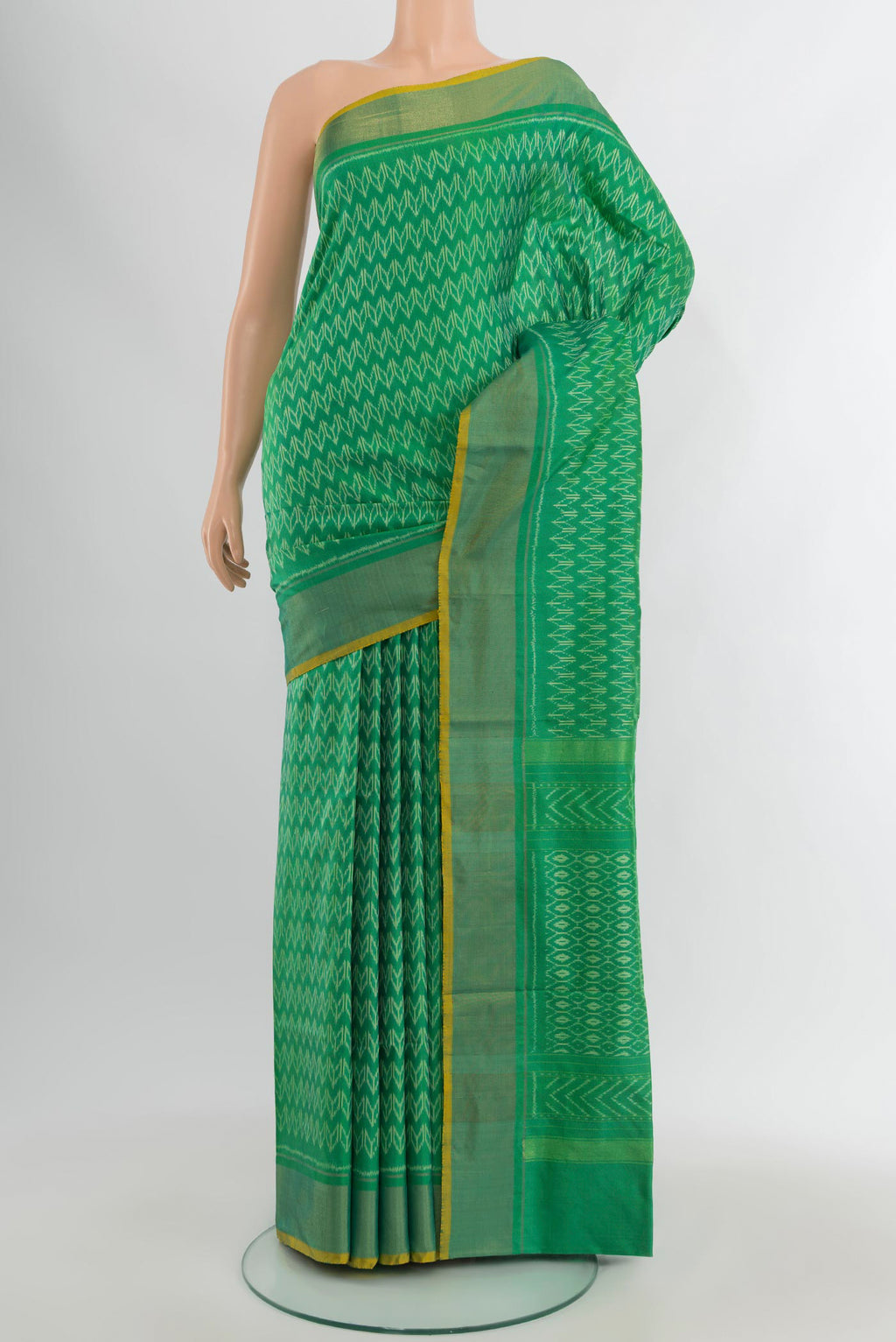 Green Pochampally Silk Saree with Ikat design on the body and Zari Border.  displayed on a mannequin