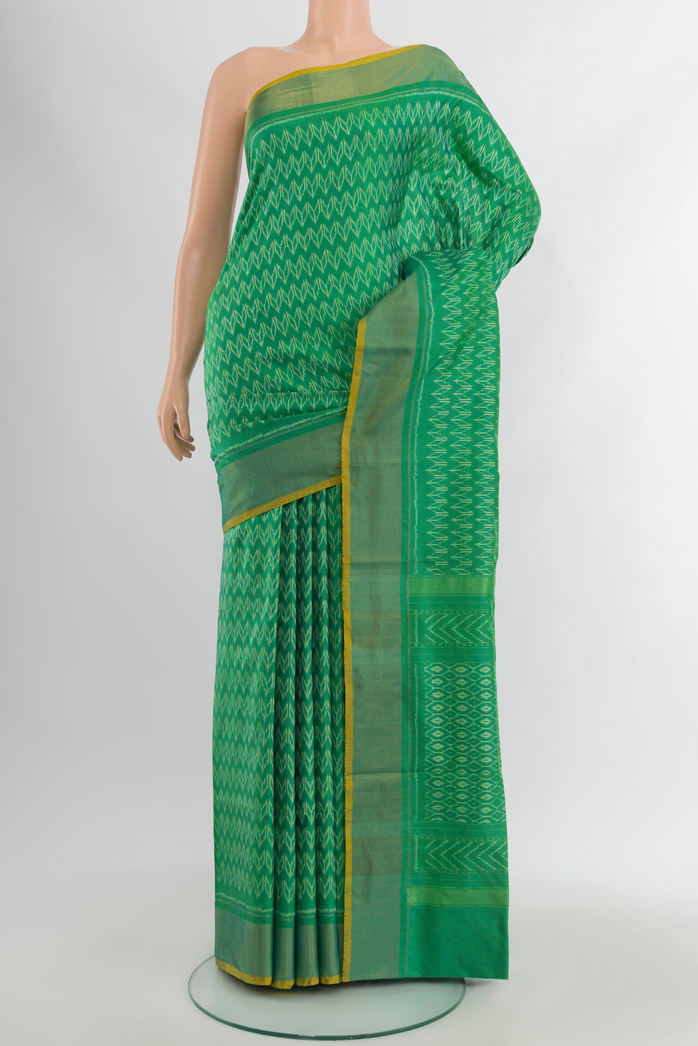 Green Pochampally Silk Saree with Ikat design on the body and Zari Border.  displayed on a mannequin