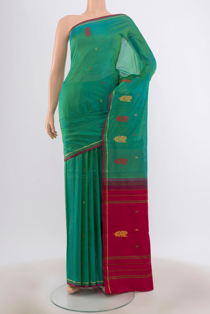 Peacock Blue Kanchipuram Silk Saree with Zari Butta on the body and Silk Border.  displayed on a mannequin