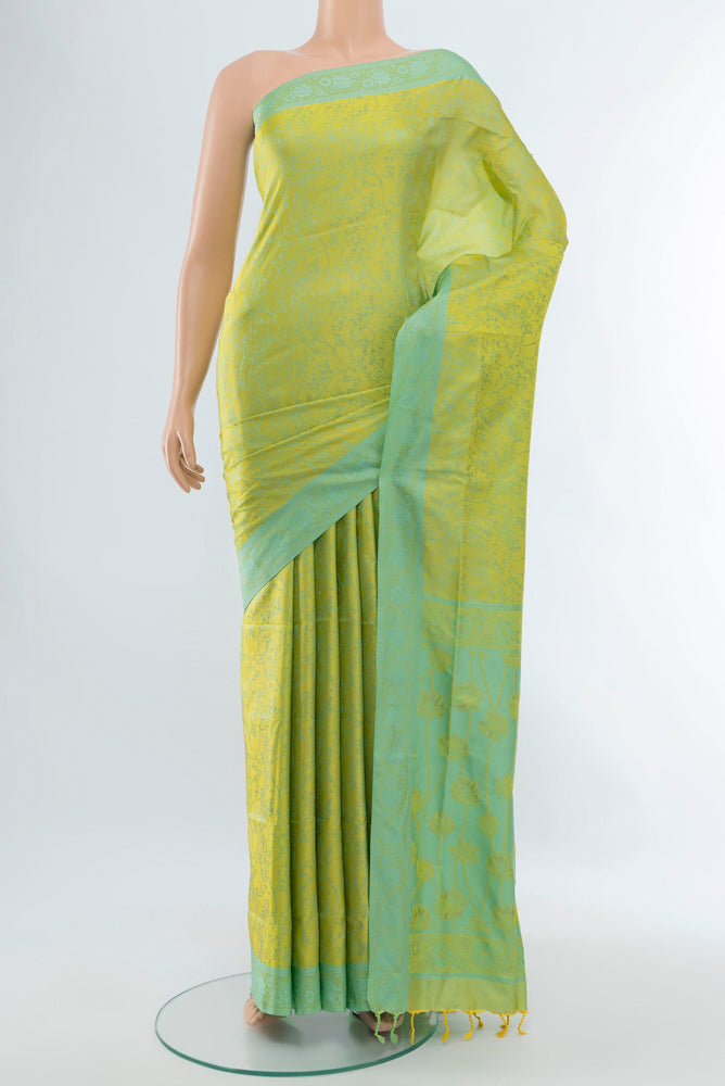 Light Green Soft Silk Saree with Zari Butta on the body and Silk Border.  displayed on a mannequin