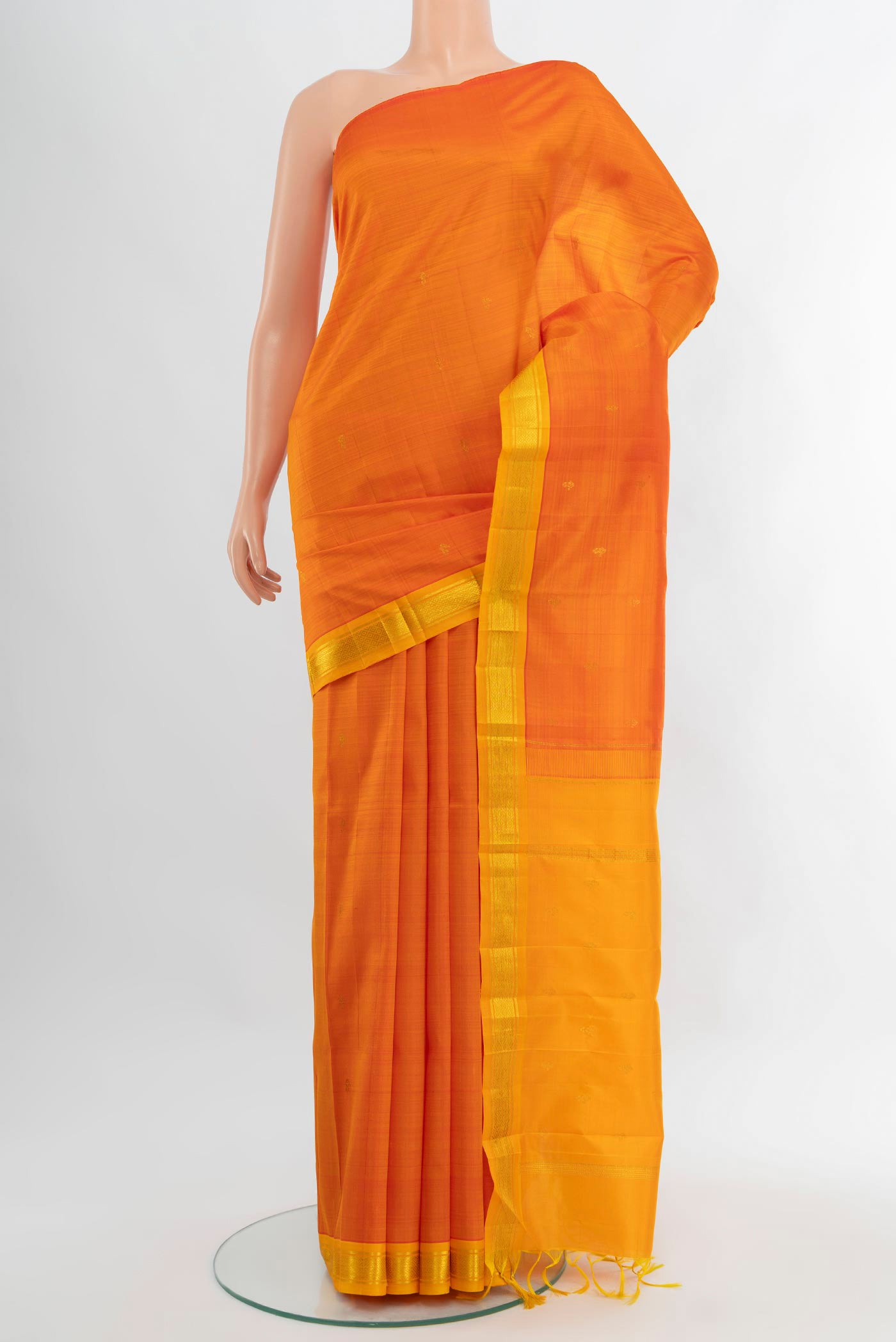 Orange Kanjivaram Silk Saree with Zari Butta on the body and One Side Border.  displayed on a mannequin